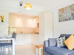 ein Wohnzimmer mit einer blauen Couch und einer Küche in der Unterkunft The Lodge At Forbury Cottage in Kimbolton