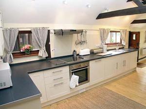 a large kitchen with a black counter top at The Byre in Ninfield