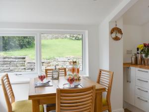 ein Esszimmer mit Tisch und Stühlen und einem Fenster in der Unterkunft Manor Park Cottage in Knitsley