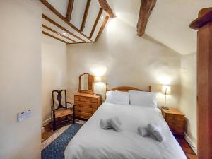 une chambre avec un grand lit blanc avec deux oreillers dans l'établissement Lobstone Cottage, à Rosthwaite
