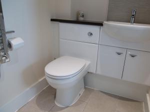 a white bathroom with a toilet and a sink at Apartment 11 - Latitude 51 in Westward Ho +3 photos