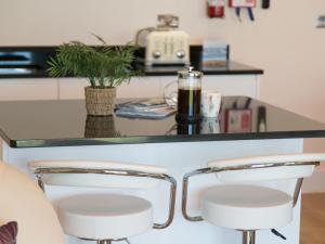two bar stools in front of a counter at Apartment 11 - Latitude 51 in Westward Ho