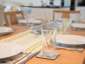 a wooden table with plates and a glass on it at Apartment 11 - Latitude 51 in Westward Ho