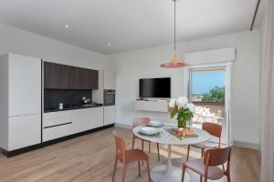 法诺Openhouse Stay的白色的厨房和带桌椅的用餐室