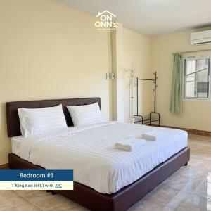 a bedroom with a large bed with white sheets at On Onn's Guesthouse in Ban Komo Sip Paet