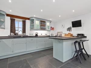 eine große Küche mit weißen Schränken und einer Theke in der Unterkunft Temple Barn in Abercastle