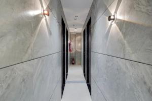 ein Flur mit weißen Marmorwänden und Lichtern in der Unterkunft Hotel O Royal Fourtune in Utrān