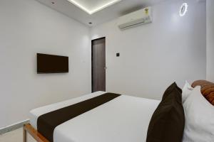 a bedroom with a bed and a tv on the wall at Hotel O Royal Fourtune in Utrān