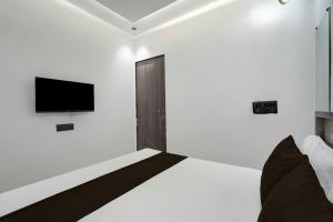 a bedroom with a bed and a tv on the wall at Hotel O Royal Fourtune in Utrān