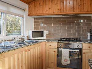 a kitchen with a stove and a microwave at Tranquillity in Millom