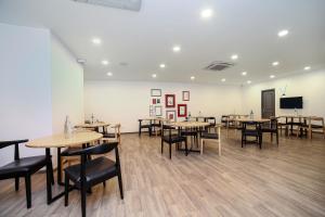 新德里Hotel O Qotel Hotel chhatarpur的客房设有桌椅和平面电视。