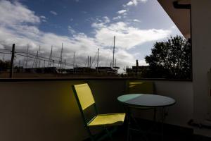 a balcony with a table and chairs and a view of a harbor at Casa twins in Fiumicino