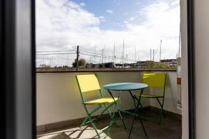 a table and three chairs sitting on a balcony at Casa twins in Fiumicino