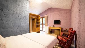 ein Schlafzimmer mit einem Bett und einem Schreibtisch mit einem Computer in der Unterkunft Welt Bungalows Belenbaşı in Hurmaköy