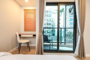 a bedroom with a bed and a desk and a window at New condo near the sea, Laguna, Choeng Thale 324 in Ban Thalat Choeng Thale +45 photos