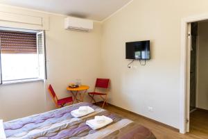 a bedroom with a bed and a table and a tv at Casa twins in Fiumicino
