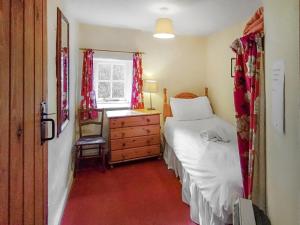 une chambre avec un lit, une commode et une fenêtre dans l'établissement Lobstone Cottage, à Rosthwaite