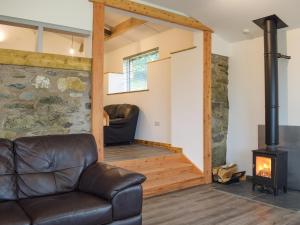a living room with a couch and a wood stove at Llety'r Saer in Pen-y-bont-fawr