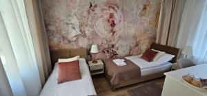 a bedroom with two beds and a painting on the wall at Apartamenty Natural in Drawsko Pomorskie