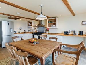 Una cocina con una mesa de madera con un bol de fruta encima. en Penmynydd Uchaf, en Dinas