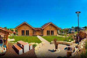 a large wooden house with a landscaping in front of it at Chalets Waldeck - Urlaub im Fränkischen Seenland 