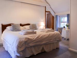 a bedroom with a bed with towels on it at Myrtle Loft in Instow +5 photos