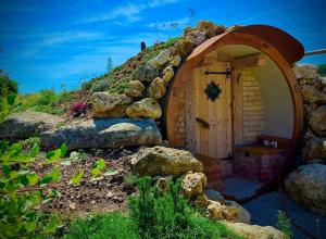 a small wooden hobbit house with a stone wall at Chalets Waldeck - Urlaub im Fränkischen Seenland 