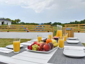 a table with a plate of fruit and glasses of orange juice at Brameley in Cheriton Bishop
