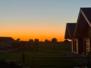 a sunset over a yard with a house at Chalets Waldeck - Urlaub im Fränkischen Seenland 