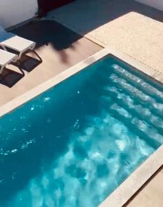 a swimming pool with two chairs and a table at Ikigai B&B in Carvalhal +135 photos