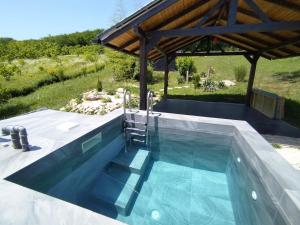 a swimming pool in a backyard with a wooden roof at Levendula Vendèghàz in Zalaszentgrót