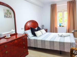 CacicedoにあるVilla Maykiのドレッサーと鏡付きのベッドのある寝室