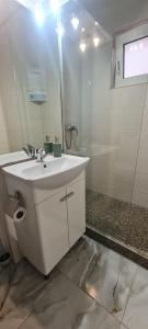 un bagno bianco con lavandino e specchio di La Bloc Apartment a Arad Altre 22 foto
