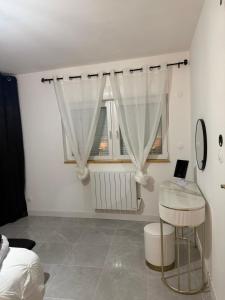 a bedroom with a table and a window with a laptop at La maison de LYA (lyaroom) in Lallaing +30 photos