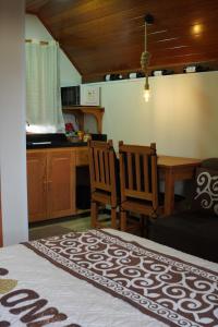 a bedroom with a table and chairs and a kitchen at Chalé Sognare Due in Santa Teresa