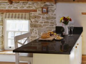 a kitchen with a black counter top and a table at The Stables By The Sea in Newquay