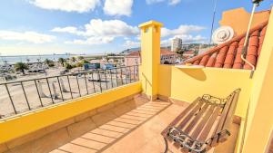 a bench on a balcony with a view of the ocean at VistaClub in Setúbal