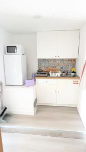 a kitchen with white cabinets and a microwave at VistaClub in Setúbal