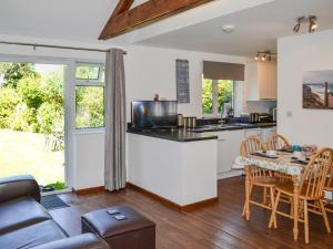 a kitchen and a living room with a table at Summer Breeze in St Austell