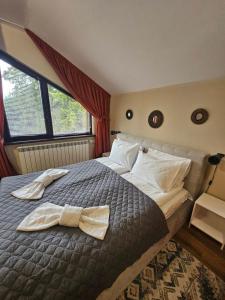 een slaapkamer met een bed met een strikje erop bij Rustic Mountain Apartment - A55 in Borovets