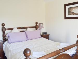 1 dormitorio con cama con sábanas blancas y almohadas moradas en Breasty Haw, en Grizedale 15 fotos más