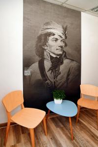 a painting of a man sitting on a chair in a room at Warsaw Hostel Centrum in Warsaw