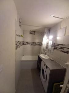 een badkamer met wastafel en wasmachine bij logement moderne in Campan