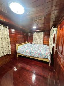 a bedroom with a bed in a wooden cabin at Peony brown in Thongsala