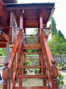 a wooden staircase leading up to a house at Peony brown in Thongsala