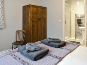 a bed with towels sitting on top of it at Lavender Cottage Was Fellside in Melmerby +10 photos