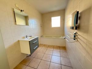 a bathroom with a sink and a bath tub at Maison plain-pied in Saint-Clair