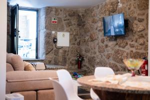 Una sala de estar con un sofá y un televisor en una pared. en Quinta do Assento, en Louredo