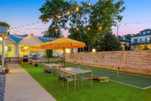 a group of tables with yellow umbrellas on a tennis court at Harmony House in Nashville
