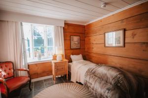 GranにあるHelgaker Gårdの木製の壁のベッドルーム1室、ベッド1台、窓が備わります。